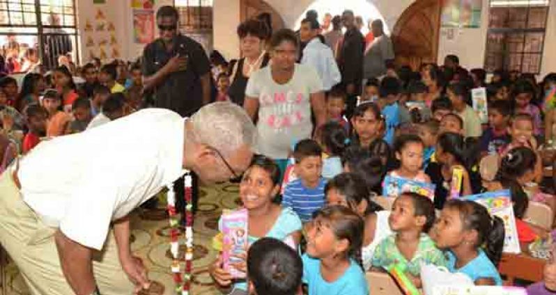 President David Granger is seen interacting with children when he visited last December. (Ministry of the Presidency photo)