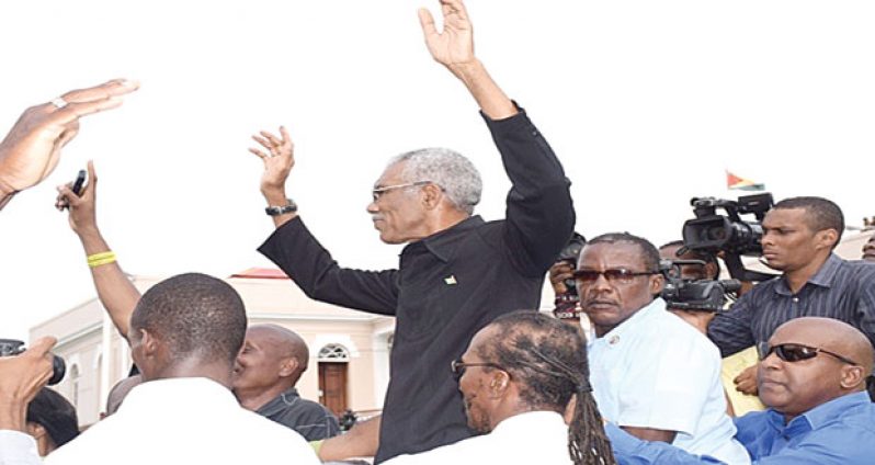 New Head of State, David A. Granger waves to supporters following his swearing-in as President of Guyana yesterday