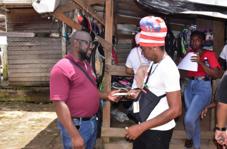 Minister of Amerindian Affairs, Pauline Sukhai, delivers the cash to a resident (DPI photo)