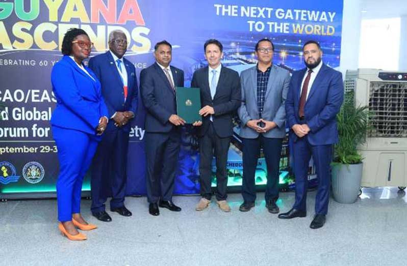 Minister of Public Utilities and Aviation, Deodat Indar, M.P., and Ambassador of the Hellenic Republic of Greece to Guyana, Theodore N. Tsakiris, together with other Guyanese officials after signing the agreement