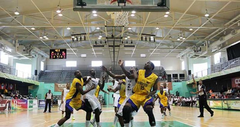 Guyana’s Dwayne ‘Brown Sugar’ Roberts and Shane Webster battle their Bajan counterparts for a rebound following a Rawle Marshall missed free throw.