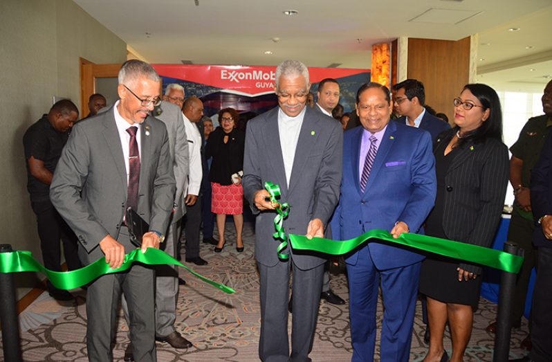 President David Granger (second right) with the assistance of Business Minister, Dominic Gaskin and Prime Minister, Moses Nagamootoo cuts the ceremonial ribbon to declare GuyTIE open (Adrian Narine photo)
