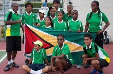 Guyana’s Inter-Guiana Games tennis unit strike a pose while displaying the Golden Arrowhead at last Thursday’s opening ceremony held at the GBTI Bel Air Park tennis court.