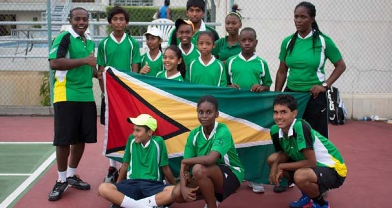 Guyana’s Inter-Guiana Games tennis unit strike a pose while displaying the Golden Arrowhead at last Thursday’s opening ceremony held at the GBTI Bel Air Park tennis court.