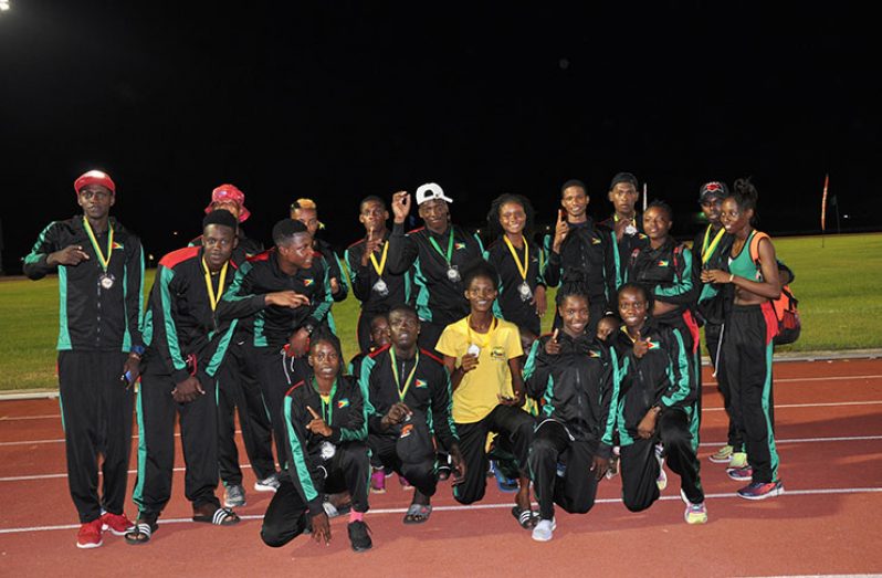 A jubilant Guyana IGG athletics team as they celebrate last night at the National Track and Field Centre in Leonora
