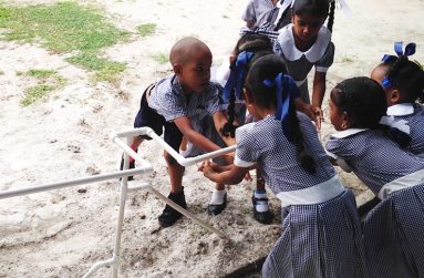 Children washing their hands from the flowing water at the Tuschen Primary School
