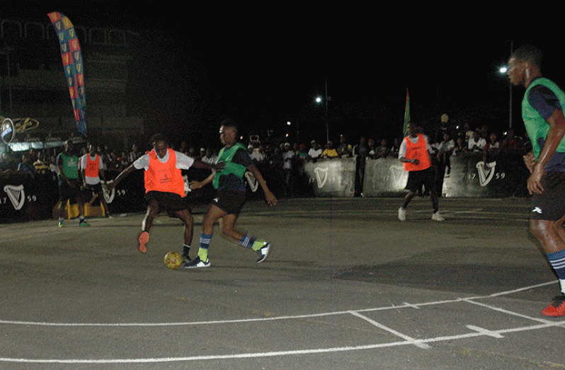 Sparta Boss’ Ryan Hackett (green bib) challenges a Judgement Yard player for the ball during their encounter on the opening night of the Georgetown Guinness ‘Greatest of the Streets’ Championship.