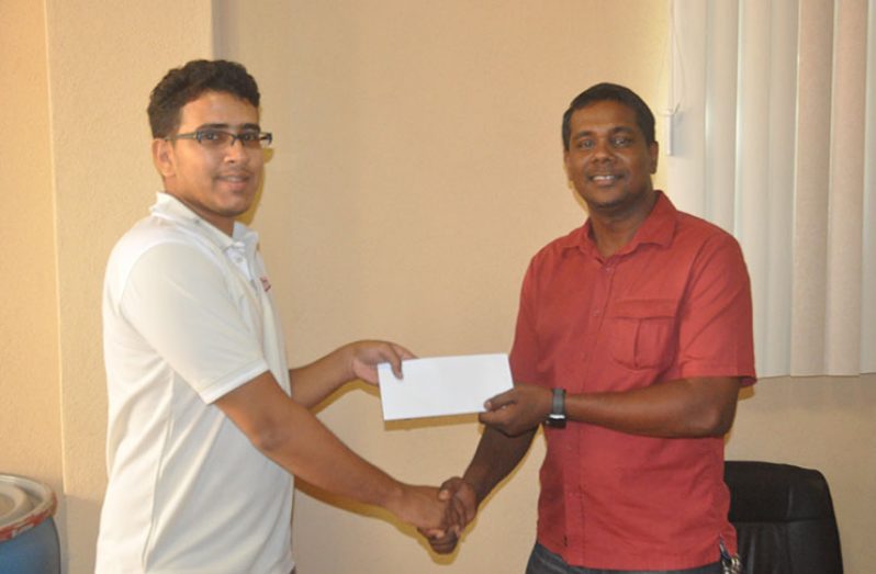 CEO of Ink Plus, Danny Persaud, (right) presents the cheque to GSCL Inc. treasurer Russel Jadbeer.