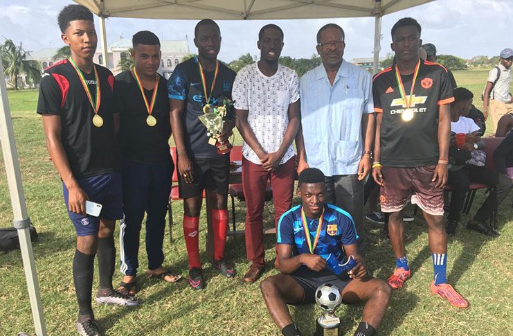 The ‘Kings of Studies’ winners, Hard Knocks, pose with organiser Jafar Gibbons (3rd from right), UG Vice-Chancellor Ivelaw Griffith (2nd from right) while tournament MVP Jermaine Samuels is seated.