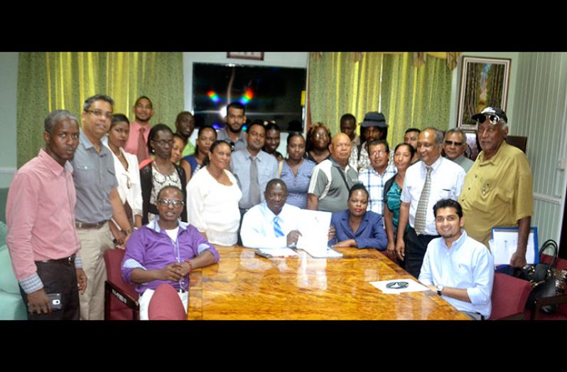 Clerk of the National Assembly Sherod Isaacs (sitting second from left) displays the petition, surrounded by members of the Guyana Hemp Association