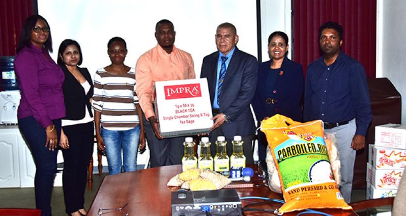 Minister of Public Health, Dr George Norton (third from right), receiving the donation from University of Guyana Masters in Public Health students