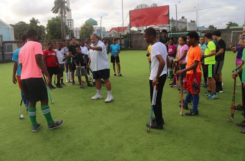 Young hockey players paying attention to FIH coach Shiv Jagday (centre) during a training session at the GCC ground, Bourda on Monday.