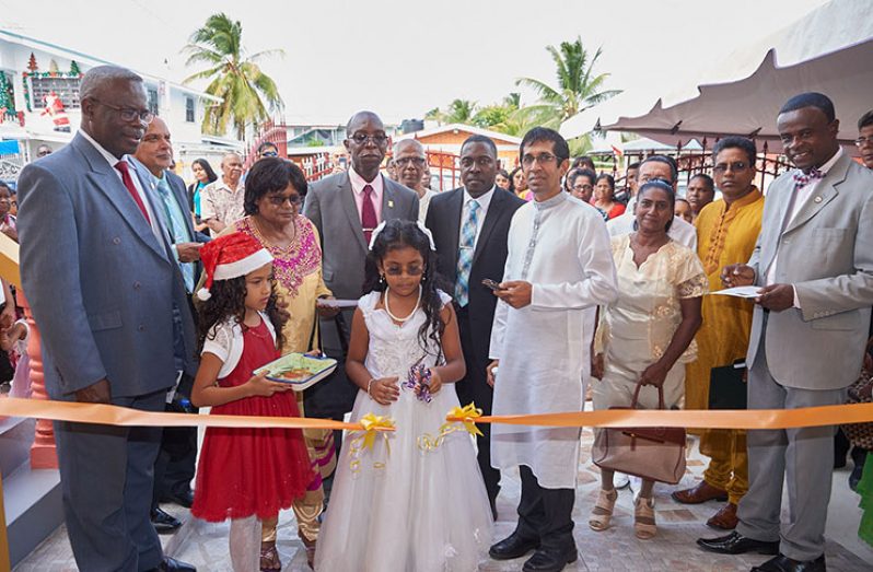 Community members and SDA leaders cutting the ceremonial ribbon to formally declare the Centre open. From left are: CARU President, Pastor Kern Tobias; CARU Religious Liberty Director, Dr. Clive Dottin; Director for Missions, Pastor Margaret Ramsarran;  SDA President, Pastor Richard James; Executive Secretary of the local conference, Pastor Exton Clarke and others