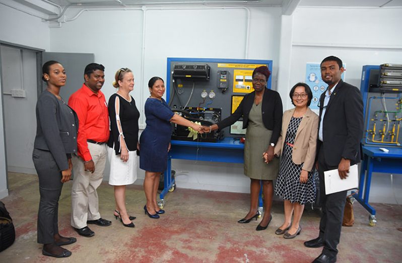 Deputy Vice-Chancellor of PACE, Dr. Paloma Mohamed (fourth left) accepts the donations presented by the Permanent Secretary of the Ministry of Agriculture, Delma Nedd (third right) and UNDP Representative Mikiko Tanaka (second right). Also present in the photo are Assistant Dean of the Faculty of Technology, Dionne Holder (first left); Head of the Mechanical Engineering Department, Vishal Persaud (second left); Dean of the Faculty of Technology, Elena Trim (third left) and Chief Hydrometeorological Officer (ag) Garvin Cummings (first right) (Samuel Maughn photo)