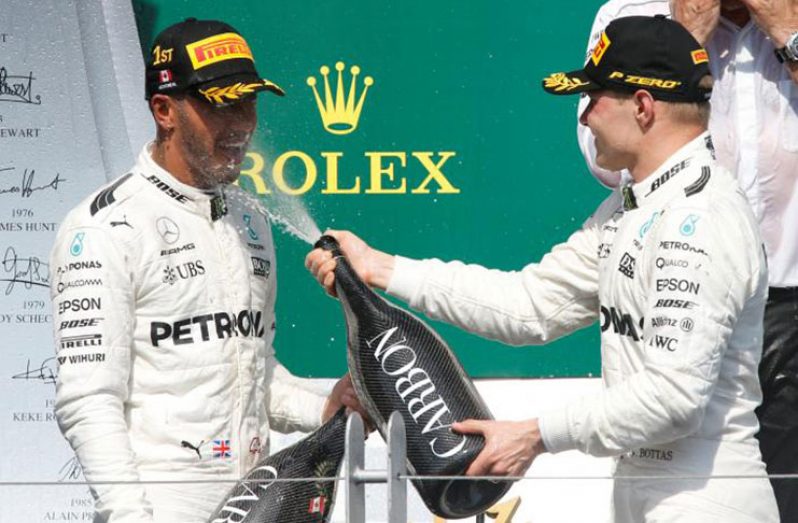 Lewis Hamilton (L) celebrates winning the race with teammate Valtteri Bottas. REUTERS/Chris Wattie