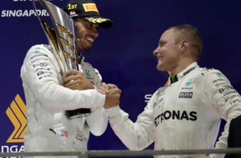 Mercedes' Lewis Hamilton celebrates winning the race on the podium with Mercedes' Valtteri Bottas REUTERS/Jeremy Lee