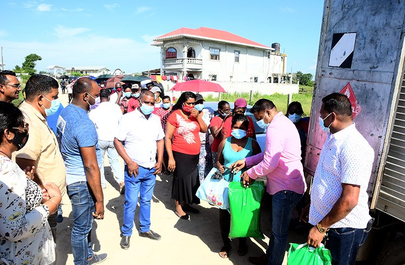 Minister within the Ministry of Public Works, Deodat Indar, distributing the hampers to residents of Washington Housing Scheme on the East Bank of Essequibo.