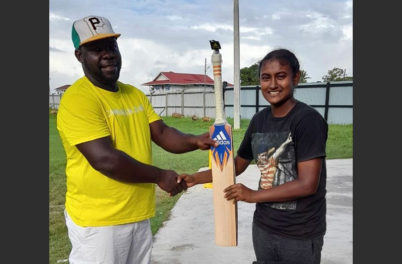 Ashmini Munisar (right) receives her tokens from Winroy Bakker.