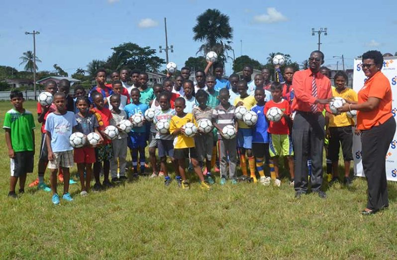 GTT PRO Allison Parker hands over a ball to Fruta Conquerors’ secretary Daniel Thomas while participants of the Youth camp look on.