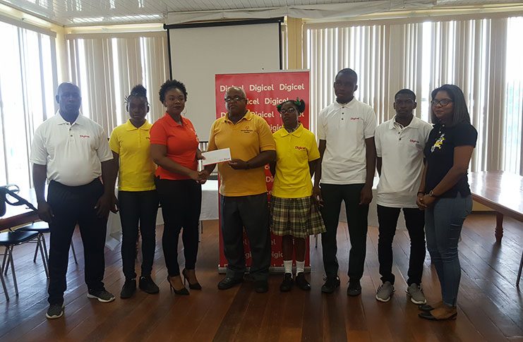 Digicel’s Sponsorship Manager, Louanna Abrams hands over her company’s support to the Head of Delegation for Special Olympics World Summer Games, Wilton Spencer.