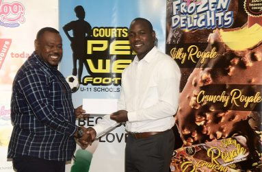 Dellon Lynch, Marketing Manager of Sterling Products Limited hands over sponsorship for the Courts Pee Wee football tournament to Petra co-director Troy Mendonca (Adrian Narine photo)