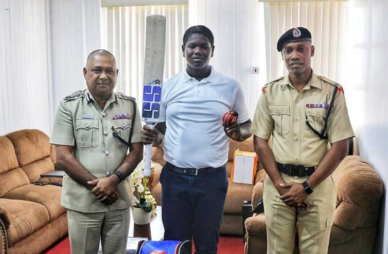 Captain of the Officers Cricket Team, Deputy Commissioner 'Administration', Mr Ravindradat Budhram (left) in his office at Eve Leary, along with Superintendent Ronald Alli, vice-captain of the Officers Cricket Team (right) flank Keon Boyce