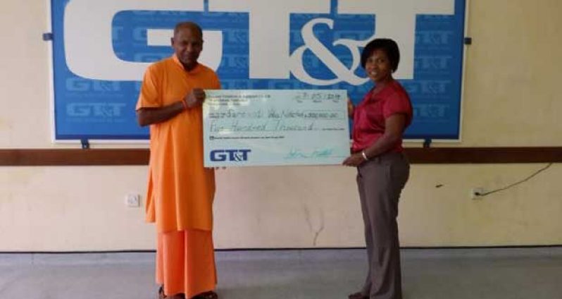 A GT&T representative (right) hands over the cheque to a representative of the Saraswati Vidya Niketan educational institution