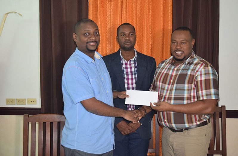 Flashback! Petra co-Director Troy Mendonca (right) receives the sponsorship cheque from New GPC Finance Manager, Duane Lovell, in the presence of GFF president Wayne Forde on Tuesday.