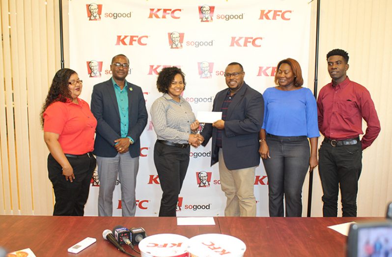 From left: Wendy Fernandes and GFF president Wayne Forde watches as Madonna Nelson hands over the sponsorship cheque to Petra co-director Troy Mendonca. Petra’s Jacquline Boodie and Mark Alleyne look on.