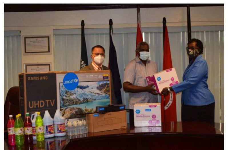Homes Affairs Minister, Robeson Benn (centre) handing over Skype recording unit and a quantity of detergents to administrator of the Juvenile Holding Centre, Yvette Sancho