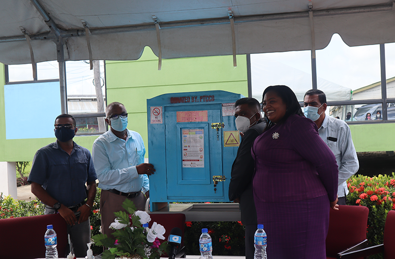 Minister Mustapha handing over one of the pesticide storage cabinets to NAREI Chief Executive Officer, Jagnarine Singh as others look on