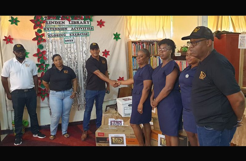 Members of the newly formed civic group 10Forward handing over the books to staffers at the National Library in Linden, Region 10