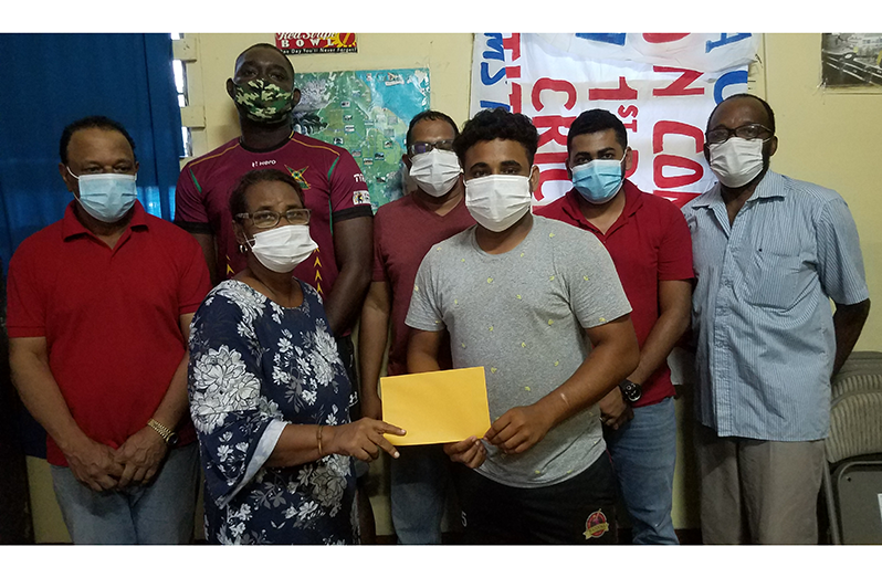 BCB Public Relations Officer, Simon Naidu, hands over the sponsorship cheque to Secretary Angela Haniff on behalf of Shimron Hetmyer.