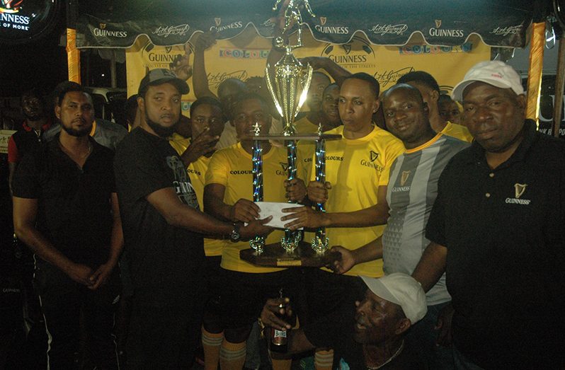 Jeoff Clement, Guinness Brand Manager, handing over the championship trophy to Ballerz Empire after winning the Guinness ‘Greatest of the Streets’ East Bank/West Demerara zone