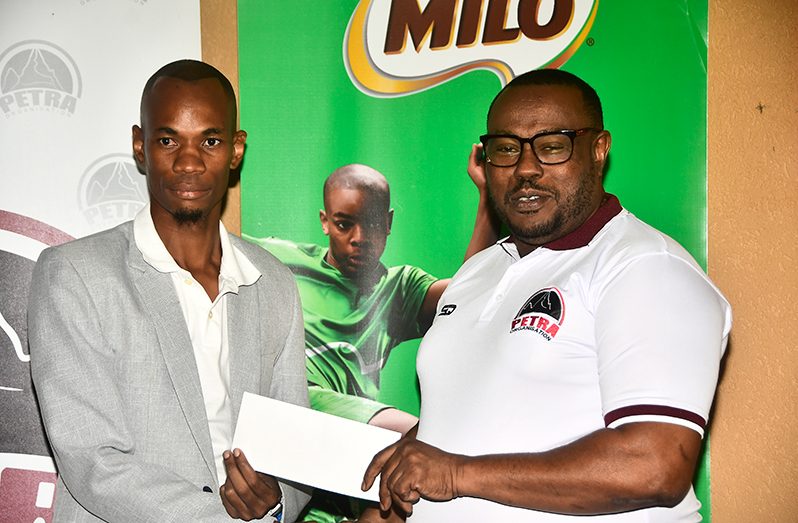 Troy Mendonca (right) is all smiles as he collects a sponsorship cheque from MVP’s Selvin Apple (Adrian Narine Photo)