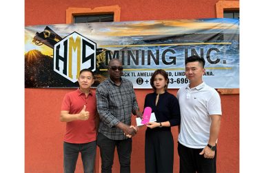 HMS Mining Inc. Executive Secretary, Di-Yi Lin hands over a cheque to Aubrey ‘Shanghai’ Major in the presence of Managing Directors, Hualeng Liang and Jie Lin