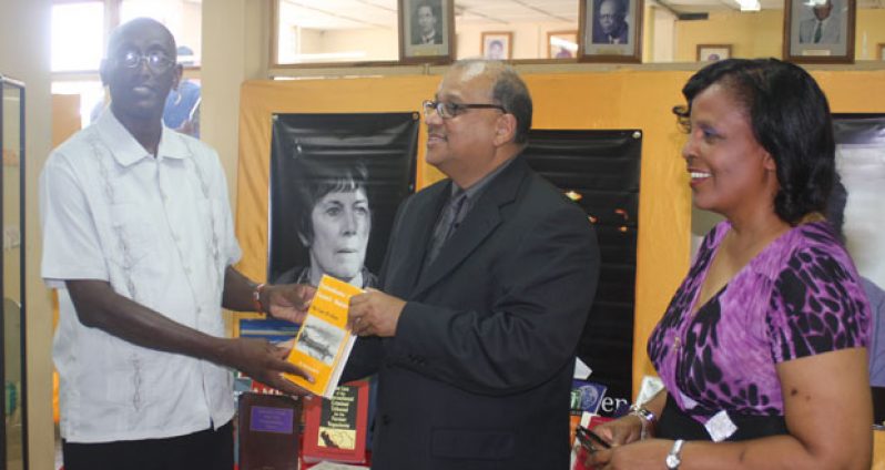 Mr. Sieyf Shahabuddeen (at centre) making the presentation to UG’s Deputy Vice Chancellor Phillip Da Silva, in the presence of Librarian Gwyneth George.