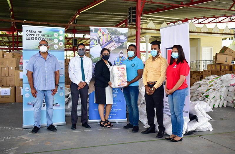 Canada-Guyana Chamber of Commerce’s CEO, Natalia Seepersaud, handing over some of the items to Civil Defence Commission, Public Relations Officer, Patrice Wishart, as others look on