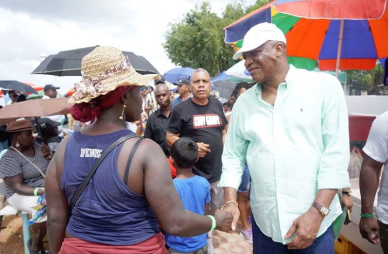 Minister of State Joseph Harmon meeting and greeting patrons on Bartica beach
