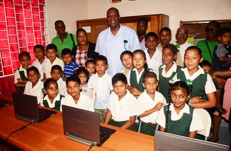 Minister of State Joseph Harmon and children of the Lower Bonasika Primary School in their new computer lab (Adrian Narine photos)