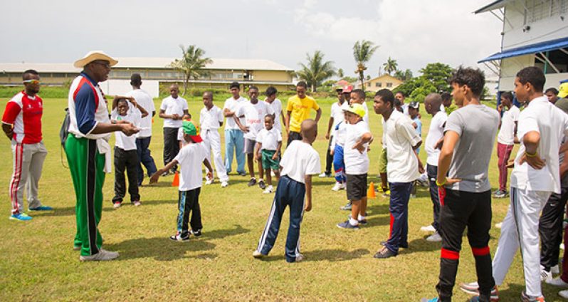 Coach Mark Harper briefing participants before the start of the youth cricket academy. (Samuel Maughn photo)