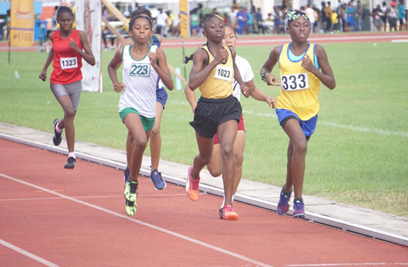 West Demerara’s Attoya Harvey (first from right) on her way to win the Girls’ U-14 1500m, in a record-setting time of 5:07.47 ahead of Rupununi’s Vannytta Francis (second from right) and Upper Demerara’s Hannah Joseph (third from right).