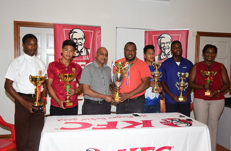 Team captains pose with trophies and officials, ahead of the KFC goodwill tournament set to begin tomorrow. (Adrian Narine photo)