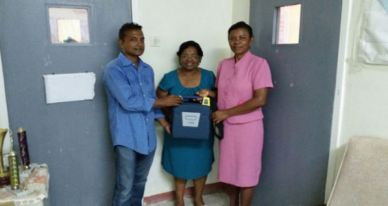 Ms. Merlene Ferrier (centre), steward of the Bartica Hospital, and  Ward Sister, Ms Cecilia Austin (right) receiving one of the defibrillators from GMR’s Mr Sharir Chan  last week