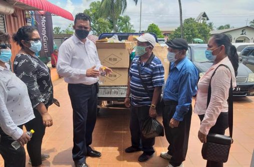 Region Two Chairman, Devanand Ramdatt chats with the village captains before handing over the items at Charity on Monday