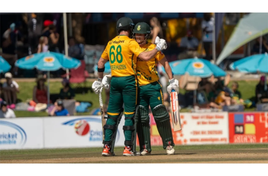 Jordan Hermann celebrates his 50 with Connor Esterhuizen  •  Cricket Namibia