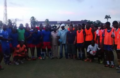 Commander of ‘A’ Division within the Guyana Police Force Clifton Hicken (centre) poses for a photo with both teams after the game.