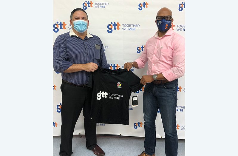 Orson Ferguson, GTT’s Chief Marketing Officer (R), hands over one of the jerseys sponsored by the company to Philip Fernandes.