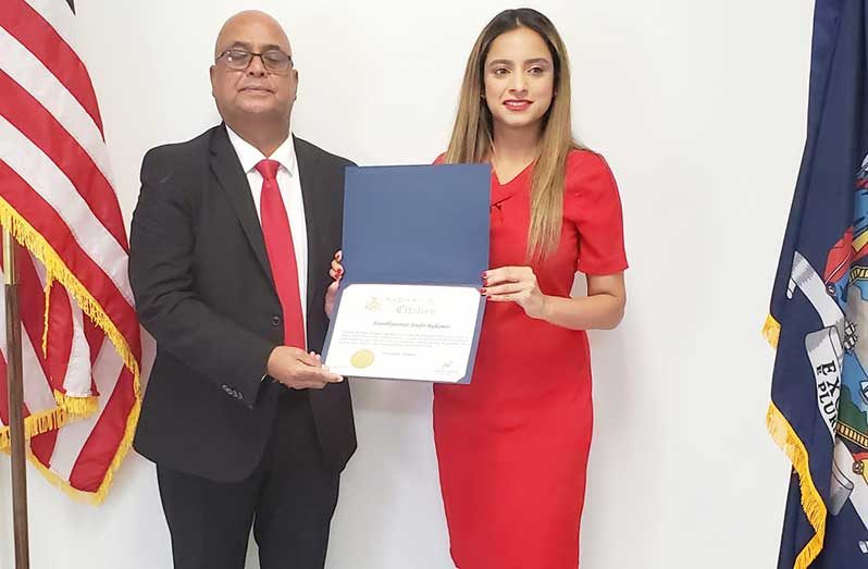 President of Guyana Oil and Gas Energy Chamber, Manniram Prashad, receives the citation from New York State Assemblywoman, Jenifer Rajkumar