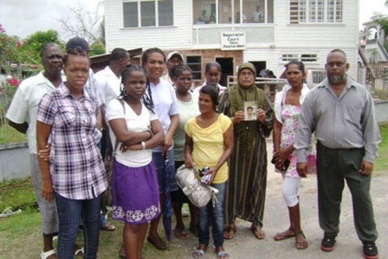 ‘FLASH BACK’: Relatives of the twelve persons who were involved in the horrific Berbice accident, pose for photographers outside the previously used New Amsterdam Magistrate Court building